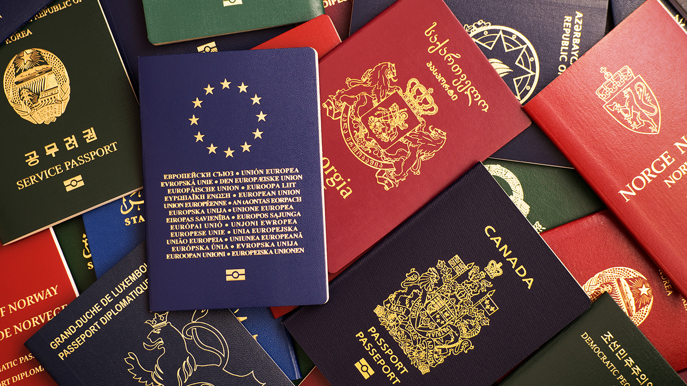 A messy pile of passports from all different countries.