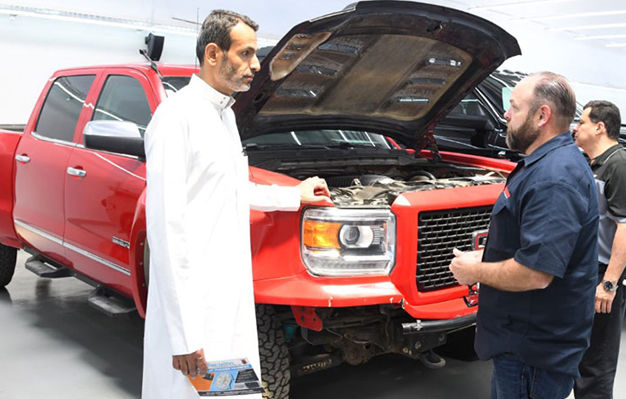 Men talking beside truck with hood up