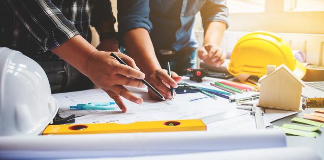 image of people working on an architectural and engineering plan