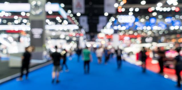 Trade show floor with people walking by booths