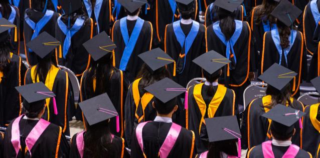 Image of graduates in black gowns from the back