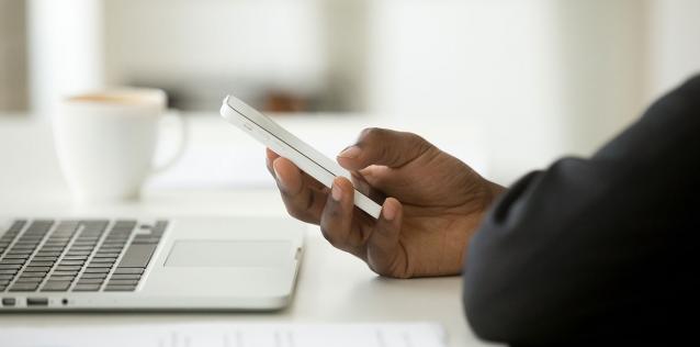 Person at computer using phone