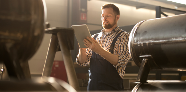 Man works on tablet in work room. 