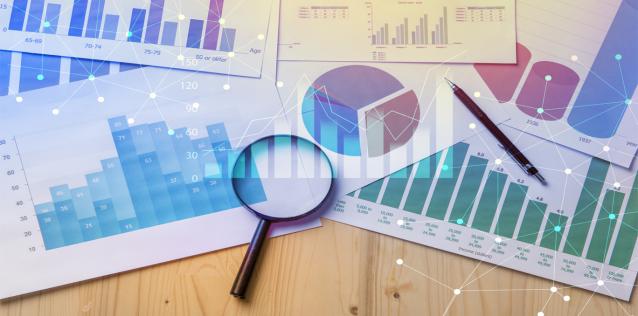 Market research graphs on paper and a magnifying glass