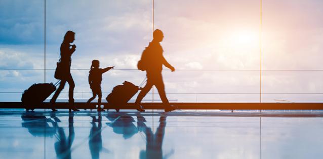 silhouette of family walking in airport at sunset
