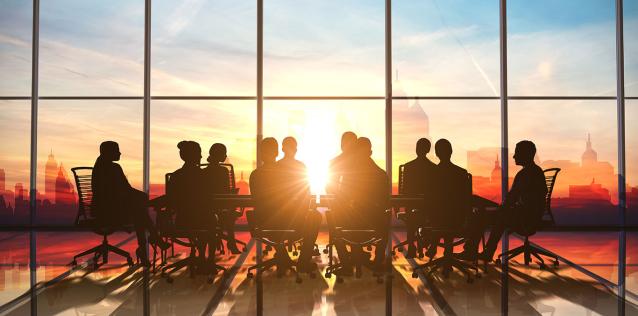 A board meeting against a a sunset cityscape