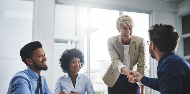 Four smiling professionals in business meeting