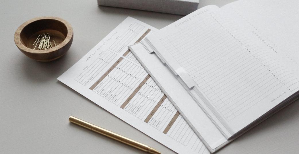 Tax documents on table with pencil and paperclips.