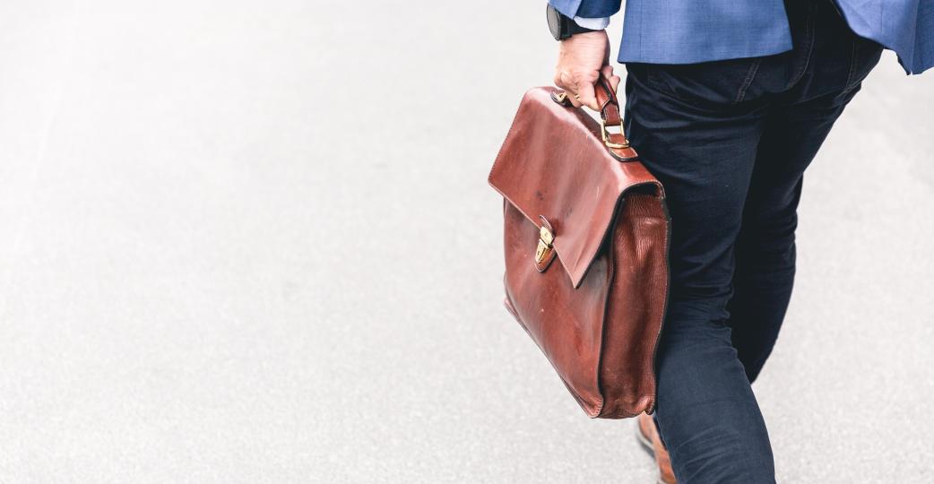 Guy in suit carrying a brown briefcase