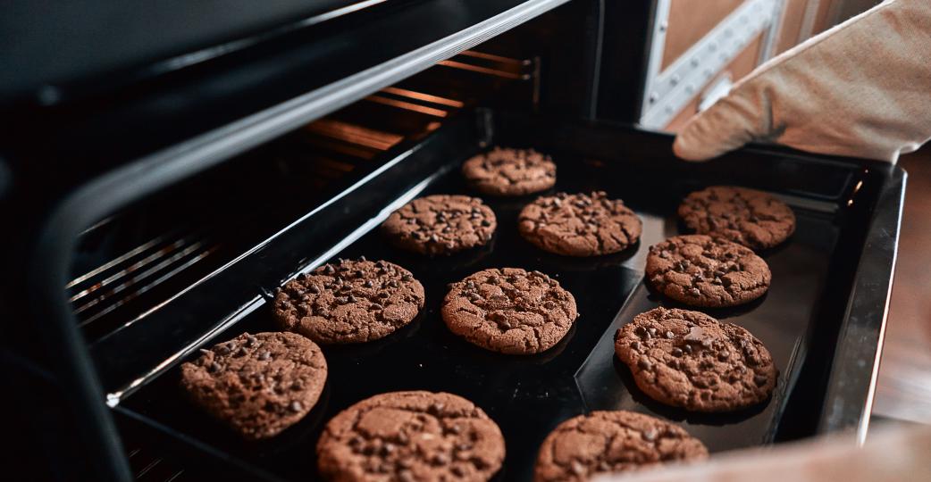 Chocolate cookies being taken out of the oven