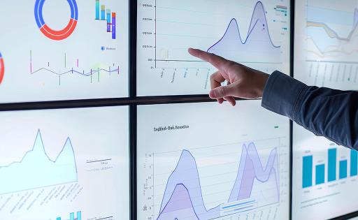 businessman points at a large screen displaying graphs and charts of data analytics